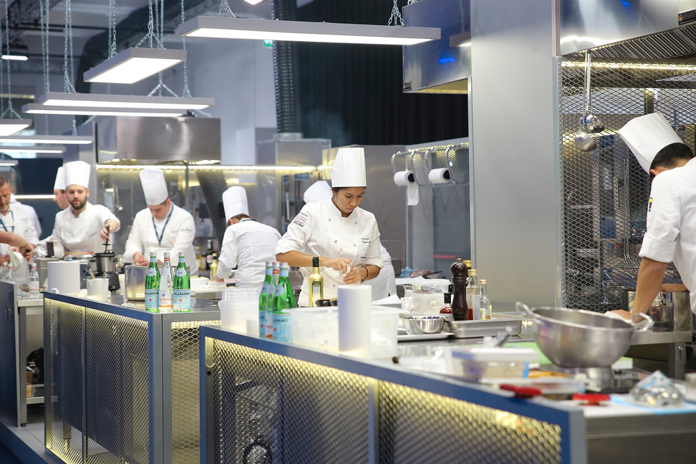 Fotografia in cucina con chef impegnati a preparare piatti per la San Pellegrino Young Chef del 2018