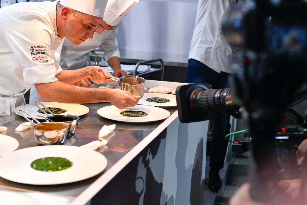 Inquadratura di uno chef mentre compone il piatto durante la San Pellegrino Young Chef del 2016