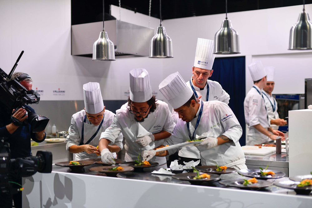 Squadra di chef si concentra sui piatti durante l_evento San Pellegrino Young Chef del 2016